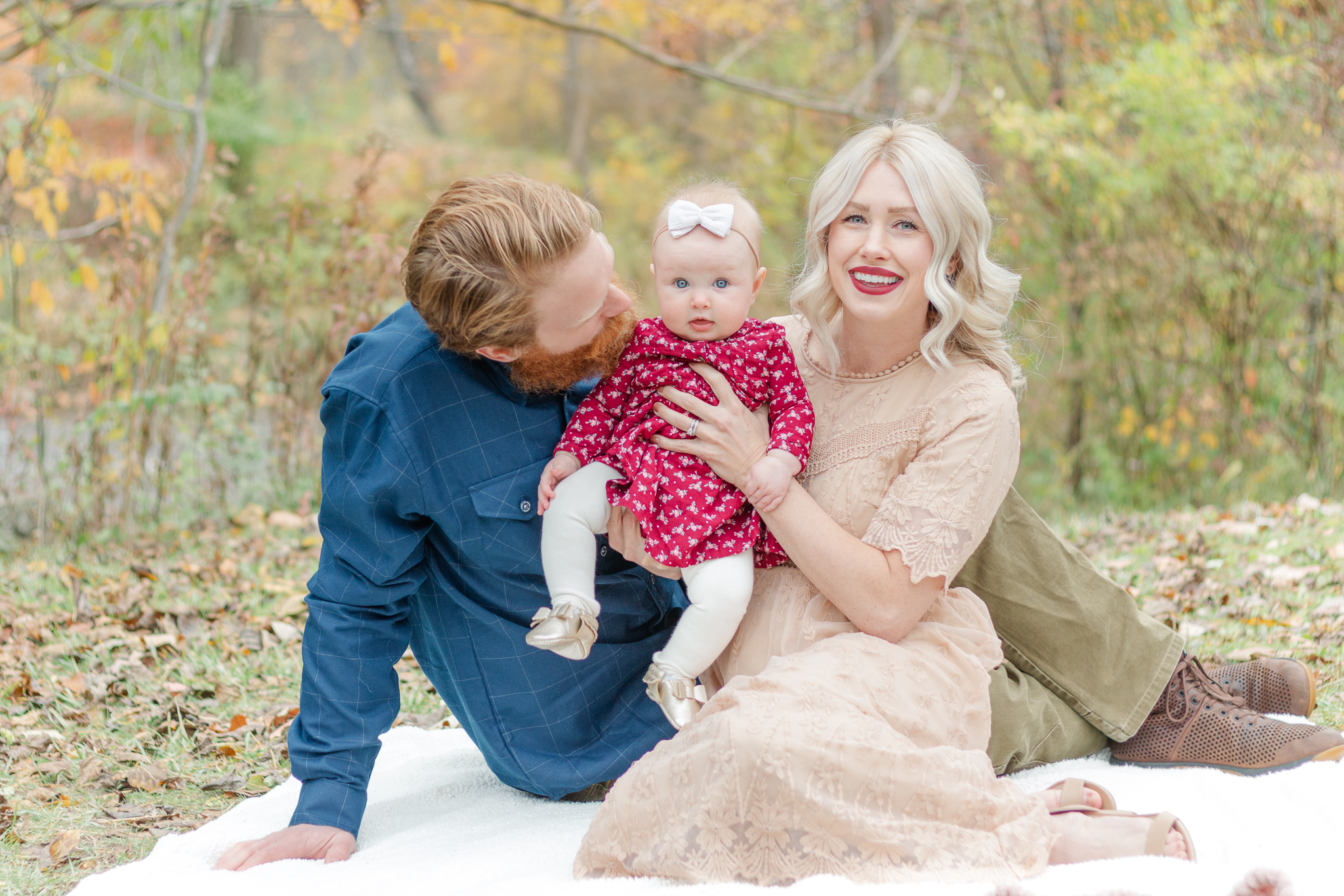 family of three posing outside in a park in rochester hills, mi