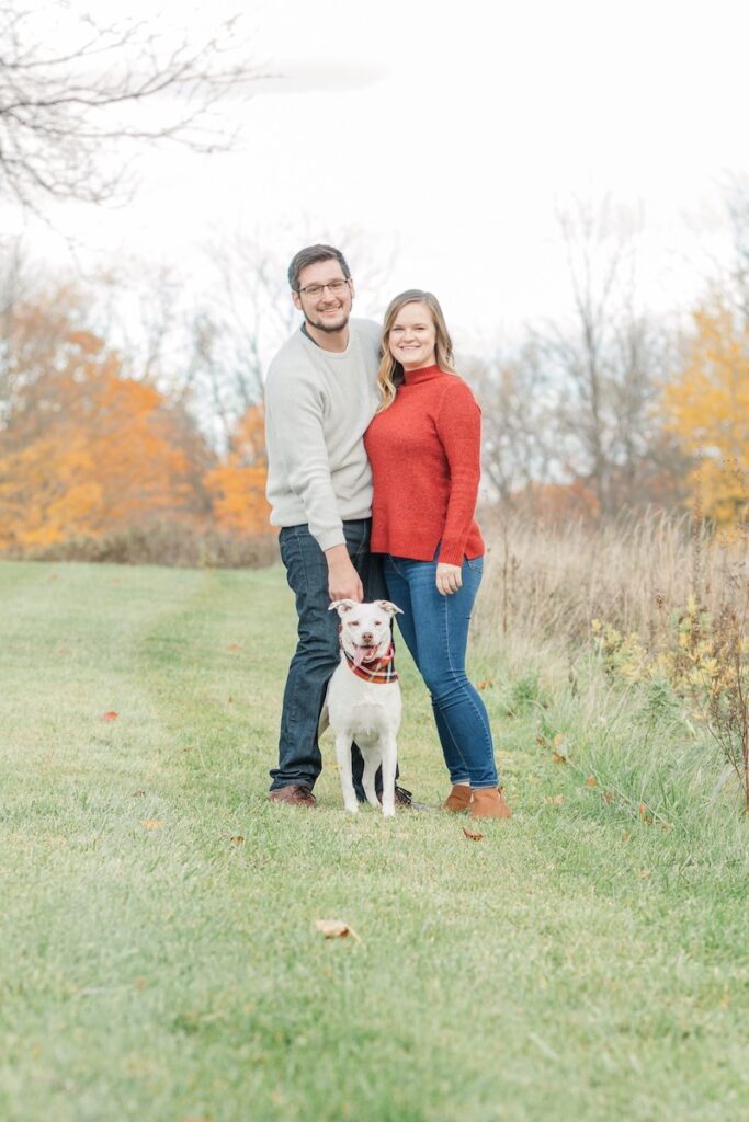 couple posing with their pet dog